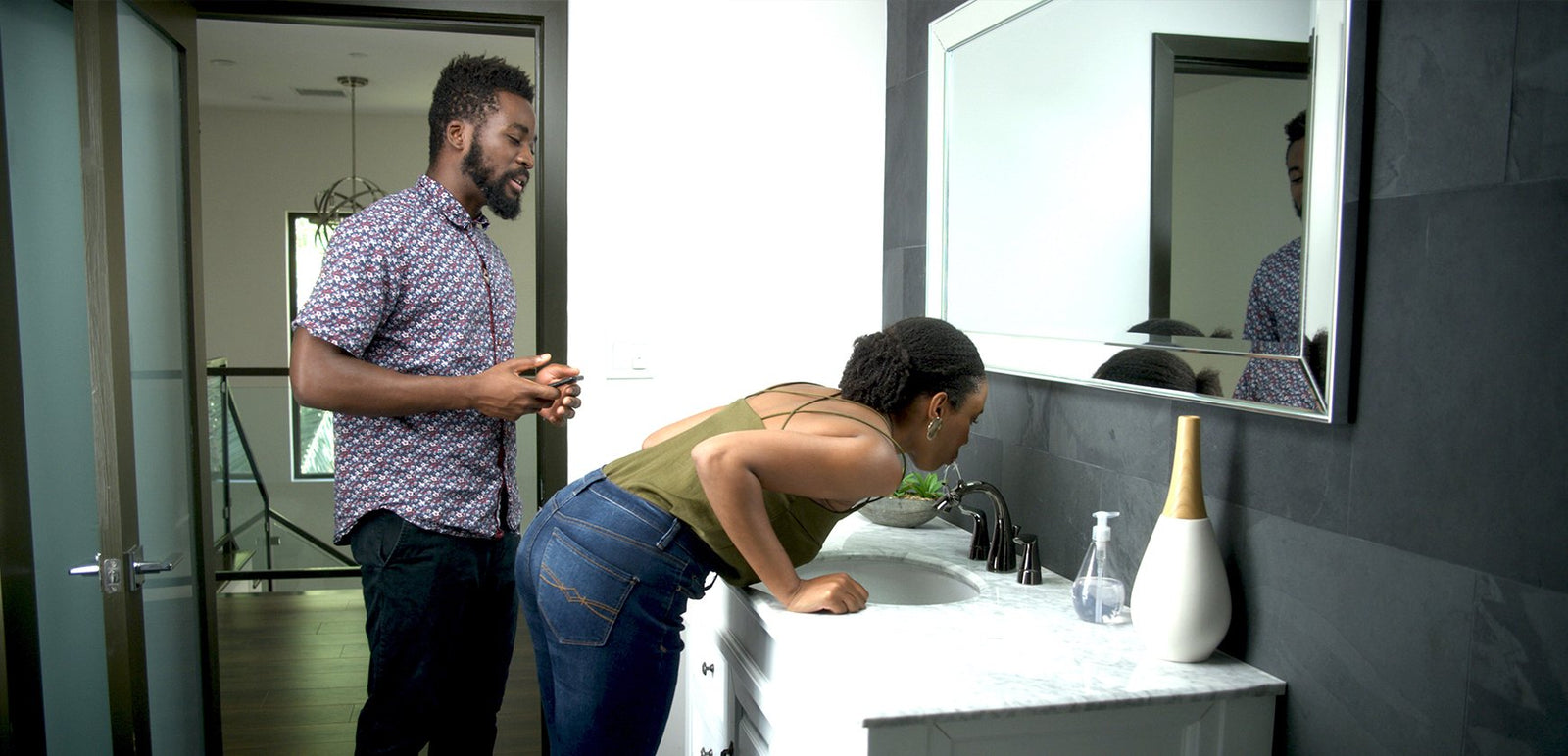 Young couple drinking water from Nasoni Fountain Faucet in modern bathroom